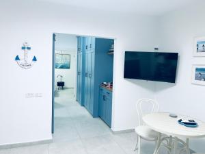 a room with a table and a tv on a wall at בלקוני לחוף דור in Dor