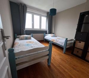 a bedroom with two beds and a window at Gîte « Les Oyats » à 400 m de la plage in Équihen-Plage