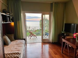 un soggiorno con un divano e una porta scorrevole in vetro di Specchio sul Lago a Manerba del Garda