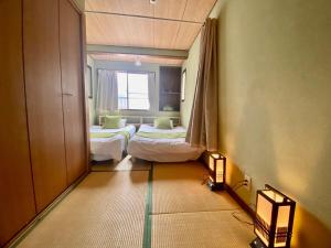 une chambre avec deux lits et une fenêtre dans l'établissement Momodani 72 two-story detached house, à Osaka