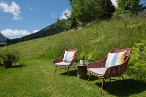 two chairs and a table in the grass at ANGELA Landhaus Fine Serviced Apartments and Double Rooms in Lech am Arlberg
