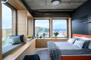 a bedroom with a bed and two windows at Headline apartments in Ljubljana