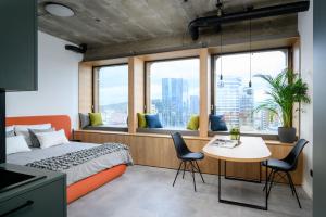 a bedroom with a bed and a table and chairs at Headline apartments in Ljubljana