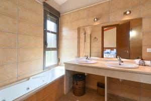 Un baño con dos lavabos, una bañera y un espejo. en Alondra, en Jávea 6 fotos más