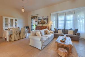 Una gran sala de estar con sofás y una mesa. en Alondra, en Jávea