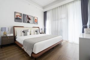 a bedroom with a large bed and a large window at 三亚海棠湾蔚蓝海湾公寓 in Sanya