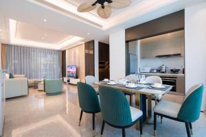 a dining room with a table and chairs at 三亚海棠湾蔚蓝海湾公寓 in Sanya