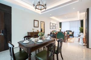 a dining room and living room with a table and chairs at 三亚海棠湾蔚蓝海湾公寓 in Sanya