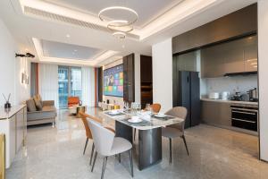 a dining room and kitchen with a table and chairs at 三亚海棠湾蔚蓝海湾公寓 in Sanya