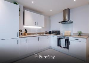 a kitchen with white cabinets and a sink at Leeds Business Stays 1-Bedroom Flat with 2 Beds & Sofa Bed - 7 nights min! in Leeds