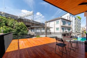 a patio with two chairs and a table on a deck at Townhouse in Khet Phayathai - Ari in Bangkok
