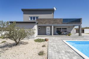 een huis met een zwembad ervoor bij Villa Grigia in Banjevci