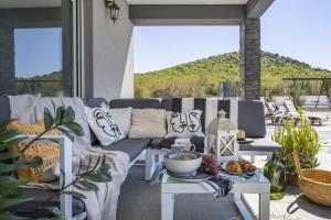 een patio met een bank en een tafel met eten erop bij Villa Grigia in Banjevci