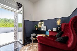 een woonkamer met een rode stoel en een raam bij Villa Grigia in Banjevci