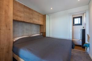 een slaapkamer met een groot bed met een houten wand bij Sea view Champagne by Vellaris, Luxury Mobile Home in Mali Lošinj
