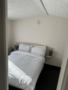 Un dormitorio con una cama con sábanas y almohadas blancas. en Seaview Holiday Rentals, en Whitstable 15 fotos más