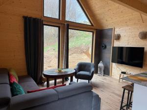 a living room with a couch and a table and a tv at Chata Przesieka in Przesieka