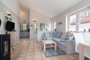a living room with a couch and a tv at Feriendorf Südstrand Haus 18 in Pelzerhaken