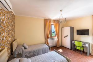 una camera d'albergo con due letti e una scrivania di Villa Vesuvio a Boscotrecase