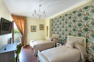 una camera d'albergo con due letti e una scrivania di Villa Vesuvio a Boscotrecase