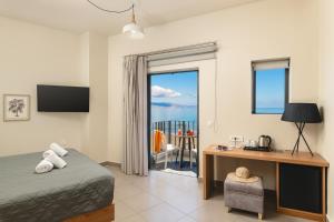 a bedroom with a bed and a desk and a window at Elia Agia Marina Hotel in Agia Marina Nea Kydonias +49 photos
