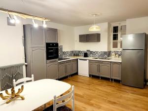 a kitchen with a table and a refrigerator at Le repaire des cloches in Saint-Florentin