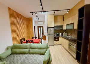 a living room with a couch and a kitchen at Orange Tree House in Tirana