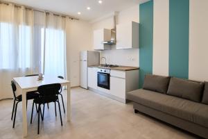 a kitchen and living room with a table and a couch at Casa Moma in Marotta