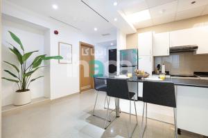 una cucina con mobili bianchi e una pianta in vaso di Luxury 1 Br Marina Near Tram Ain Sea View Balcony a Dubai