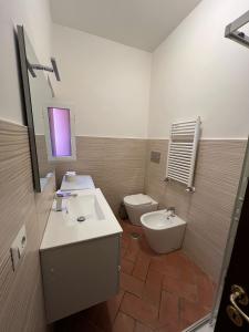 łazienka z umywalką, toaletą i lustrem w obiekcie Colosseum 20 apartment w Rzymie +8 zdjęć