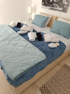 a large bed with blue sheets and pillows on it at Artist Home in Porto Rafti