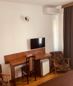 a room with a desk with a television and a chair at Hotel Moldova in Bîrlad