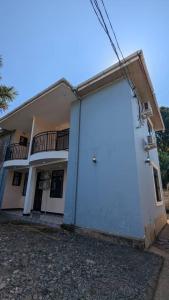 a white building with a large door in front of it at Homeland Apartments in Arusha