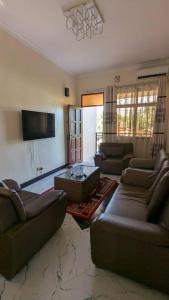 a large living room with couches and a table at Homeland Apartments in Arusha