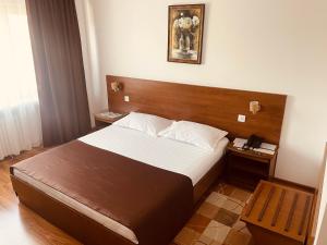 a bedroom with a large bed with a wooden headboard at Hotel Moldova in Bîrlad