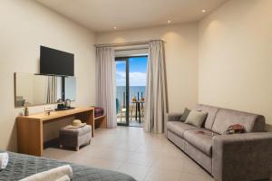 a living room with a couch and a room with a view at Elia Agia Marina Hotel in Agia Marina Nea Kydonias