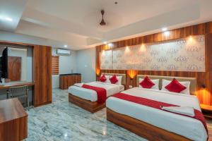 a hotel room with two beds and a flat screen tv at Daan Residency Near Karukapilly Kaloor Palarivattom in Ernakulam