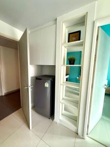 een keuken met een koelkast en witte kasten bij Better Homes at Atlantis Condo Resort in Jomtien Beach