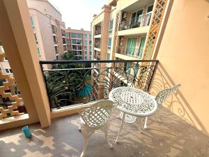 een terras met een tafel en stoelen op een balkon bij Better Homes at Atlantis Condo Resort in Jomtien Beach