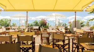 a restaurant with tables and chairs with the ocean in the background at Hotel Villa Victoria in Nice