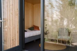 a room with a bed and a glass door at Zwier, de Vrijhaven in Vinkeveen