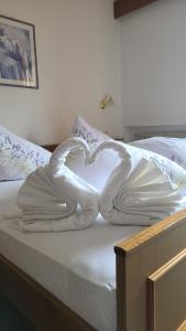 ein weißer Schwan, der auf einem Bett liegt in der Unterkunft Garni Schuster in Corzes
