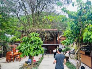 un hombre caminando por una acera en frente de un edificio en PACO HT Homestay A Lưới, en A Lưới (1)