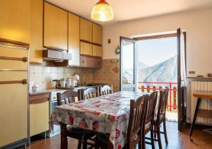a kitchen with a table with chairs and a view of a mountain at Mountain Paradise Panoramic View in Madonna della Costa