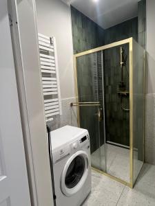 una lavatrice in un bagno con doccia di GREEN Apartment 2 a Poznań
