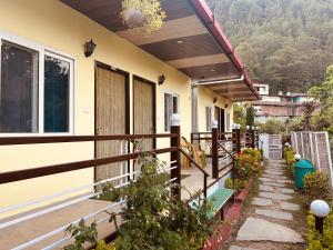 a porch of a house with a wooden fence at The Pines Mountain View in Rudraprayāg