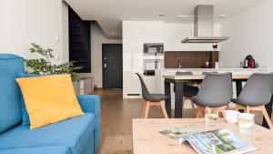 un salon et une cuisine avec un canapé bleu dans l'établissement ASTER spa & beach dúplex, à La Vila Joiosa