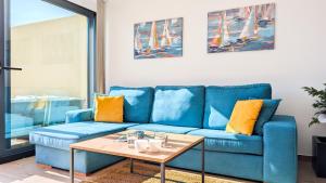 un canapé bleu dans un salon avec une table dans l'établissement ASTER spa & beach dúplex, à La Vila Joiosa