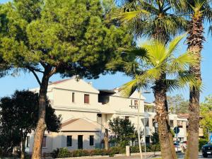 a white building with palm trees in front of it at Dalila's Apartment in Sirmione