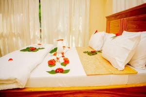 a bed with flowers and pillows on it at Anu soul paradise limite in Kikaangoni